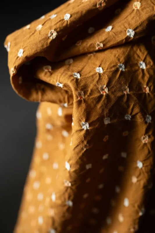 Brown fabric with white floral patterns on a dark background