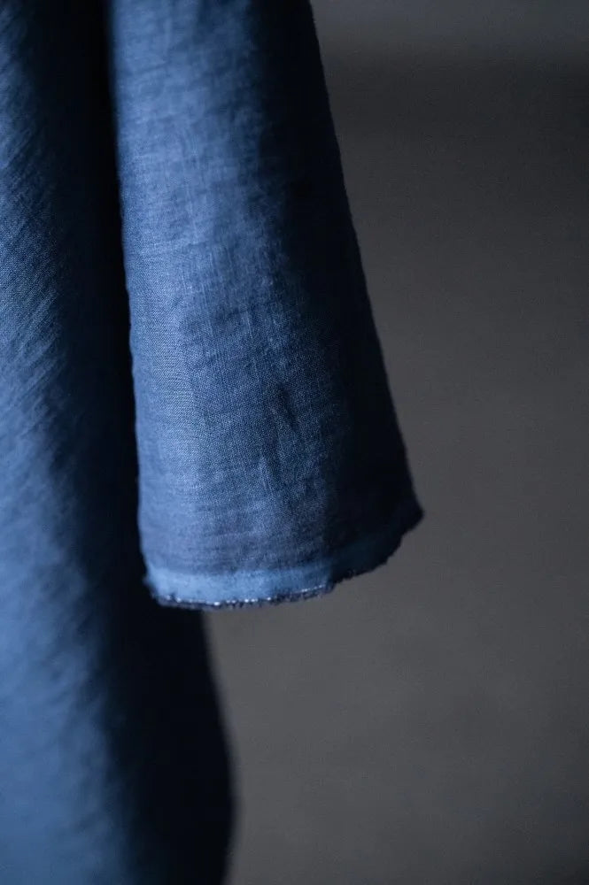 Close-up of a dark blue fabric with a textured surface on a gray background