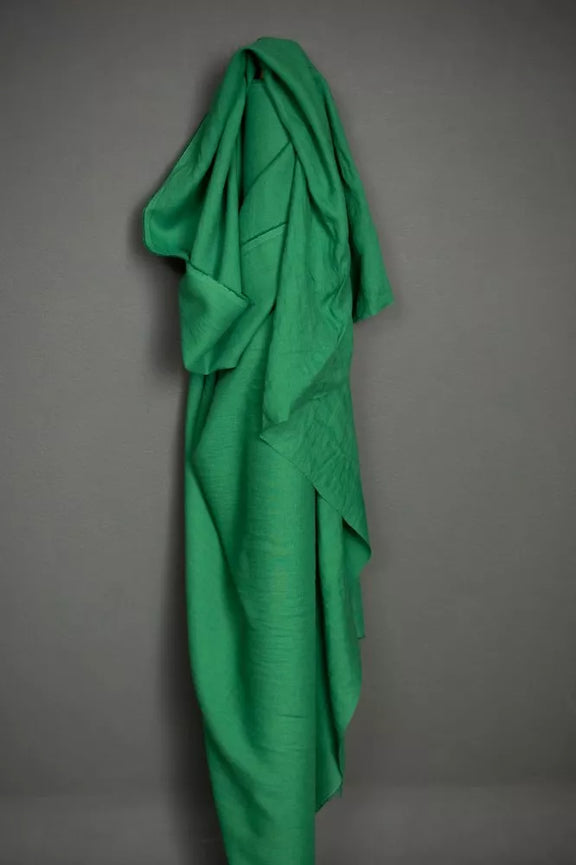 Green fabric draped over a gray wall