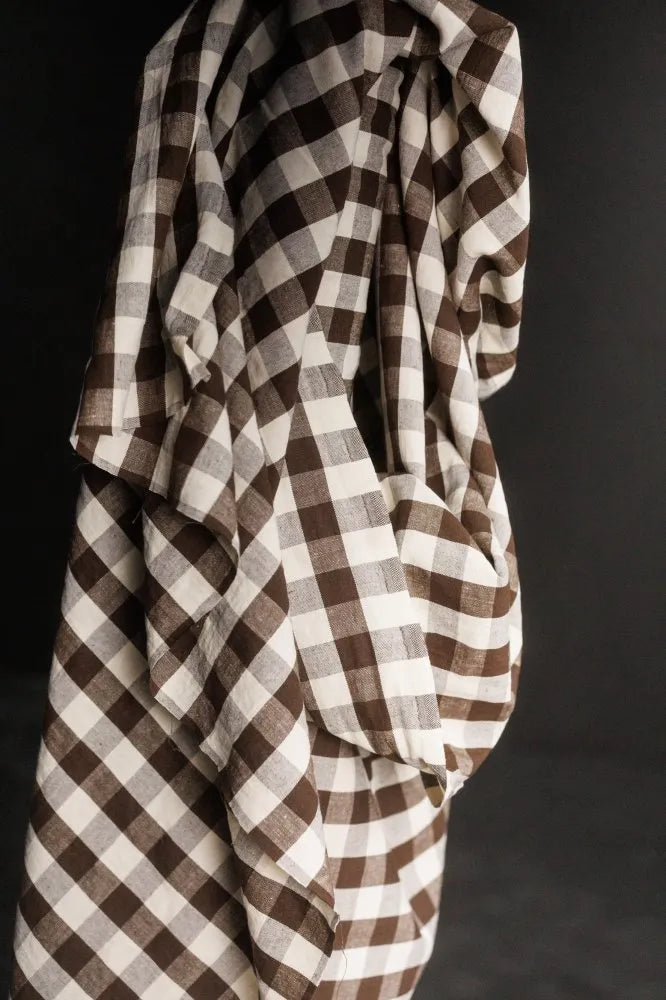 Brown and white checkered fabric draped over a dark background