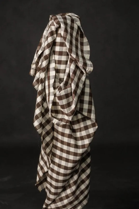 Brown and white checkered fabric draped over a black background