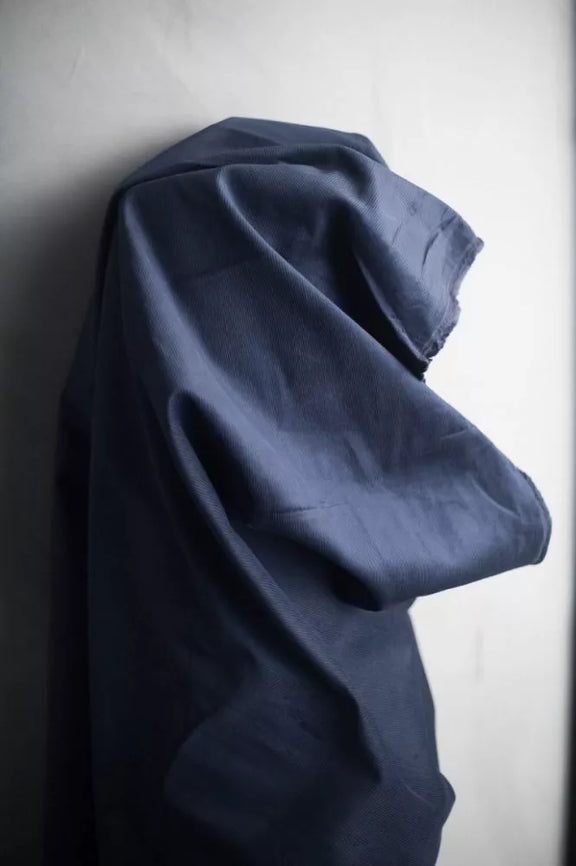Blue fabric draped over a surface against a neutral background