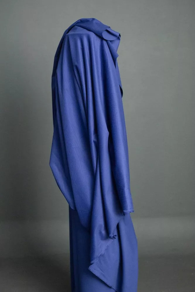 Blue garment on a mannequin against a gray background