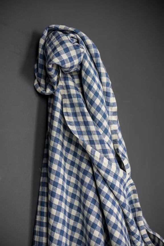 Blue and white checkered fabric draped over a gray surface